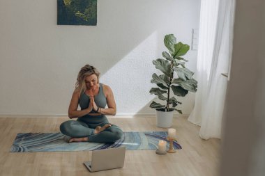 Evde internetten yoga yapan 50 yaşında bir kadın. Yüksek kalite fotoğraf