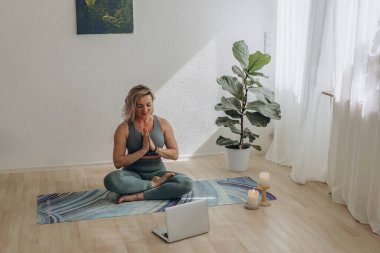 Evde internetten yoga yapan 50 yaşında bir kadın. Yüksek kalite fotoğraf