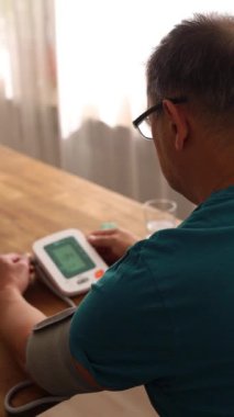 Yaşlı bir adam masada oturuyor ve evde nebulizör kullanıyor. Yüksek kalite fotoğraf