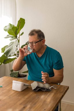 Yaşlı adam odadaki üst koldaki monitörle kan basıncını ölçüyor. Yüksek kalite fotoğraf