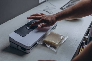 Elektrikli süpürgeyle peynir paketleyen bir adam. Yüksek kaliteli FullHD görüntüler