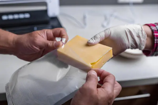stock image Close-up of mens hands sealing cheese into an airtight bag using a vacuum sealer. High quality FullHD footage