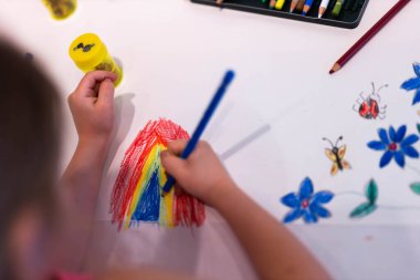 Çocuk kız renkli kalemlerle resim çizer. Yüksek kalite fotoğraf