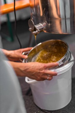 Arıcılık için makine ve ekipman. Kovaya taze bal dök. Yüksek kalite fotoğraf