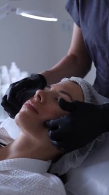Genç ve güzel bir kadın güzellik salonlarında tedavi görüyor. Yüz maskesi kullanıyor. Yüksek kalite fotoğraf