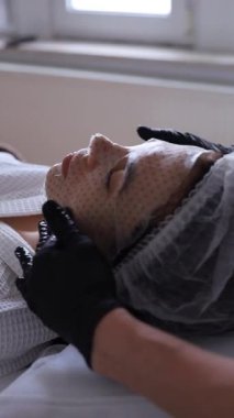 Genç ve güzel bir kadın güzellik salonlarında tedavi görüyor. Yüz maskesi kullanıyor. Yüksek kalite fotoğraf