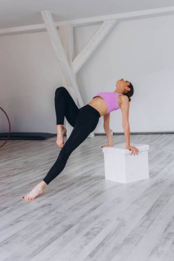 Kız jimnastikçi beden eğitiminde denge ve güç için zor bir egzersiz yapıyor. Yüksek kalite fotoğraf