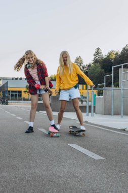 Parkta kızıyla birlikte kaykay süren genç bir anne. Anne ve genç kız. Yüksek kalite fotoğraf