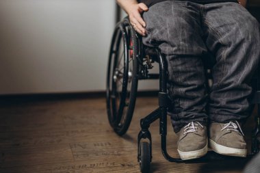 Tekerlekli sandalyede otururken pencereden bakan engelli bir genç. Yüksek kalite fotoğraf