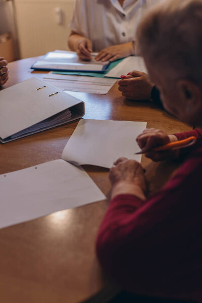 Old woman close up hand hold pen sign contract put signature.A woman signs a will. High quality photo