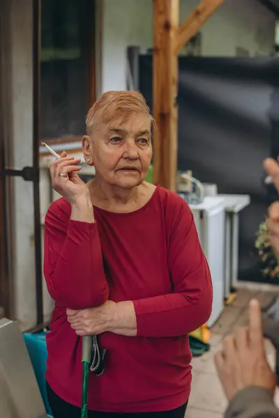 Yaşlı büyükanne evde sigara içiyor. Yüksek kalite fotoğraf