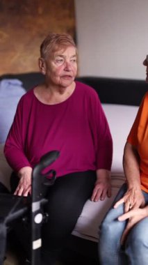 Kadın bir hemşire otururken yaşlı bir adamın kan şekerini ölçüyor. Yüksek kaliteli FullHD görüntüler