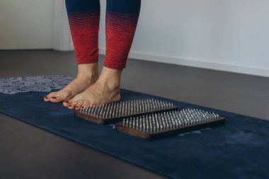 Çıplak ayaklı kadın ayağı, konsantrasyon çalışması için çivilerle tahta bir tahtanın üzerinde duruyor. Yüksek kalite fotoğraf