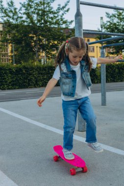 Pembe kasklı tatlı kız kaykaya biniyor. Yüksek kalite fotoğraf