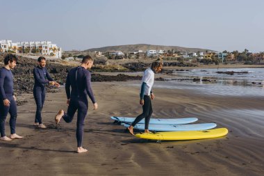 Tenerife Adası - 16 Aralık 2023: Koç sörfçü grubuna nasıl sörf yapılacağını göster. Yüksek kalite fotoğraf
