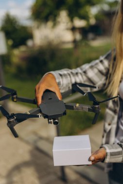 Hızlı ve güvenli teslimat. İnsansız hava aracı, bir kıza hediyesini iletir. Teslimat olmadan. Yüksek kalite fotoğraf