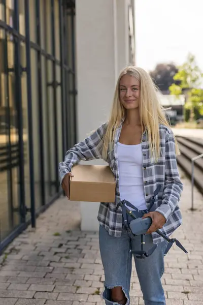 İHA teslimatı paket teslimatı. İHA teslimatı, evdeki kuryenin önünde bayan kostümcüye verildi. Yüksek kalite fotoğraf