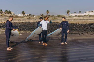 Tenerife Adası - 16 Aralık 2023: Koç sörfçü grubuna nasıl sörf yapılacağını göster. Yüksek kalite fotoğraf