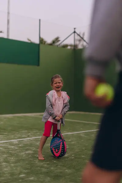 Sahada ağlayan ve tenis oynayan küçük bir kız. Yüksek kalite fotoğraf