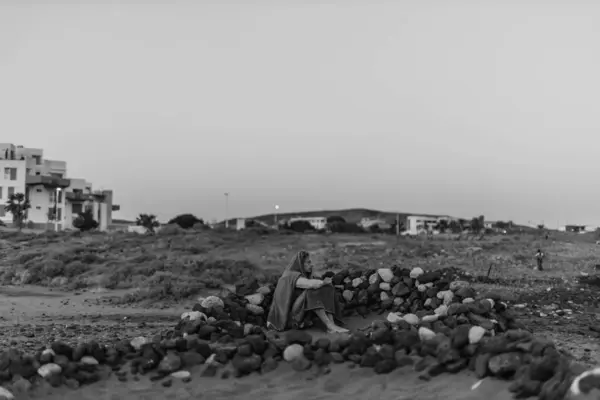 stock image Canary Island, Tenerife-December14,2023.Man surfer resting on the ocean shore, sheltered from the wind. High quality photo