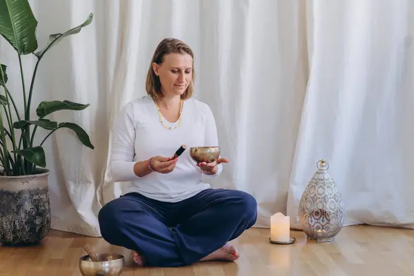 stock image Young woman playing on a singing tibetian bowl.Relaxation and meditation.Sound therapy,alternative medicine. High quality photo