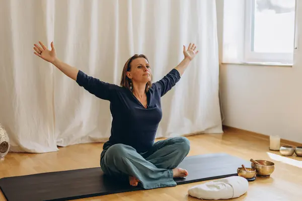 stock image A woman sits on the floor with her eyes closed, practicing deep breathing exercises. She inhales and exhales slowly. High quality photo