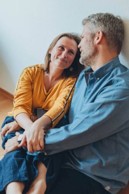 Mutlu bir çift yerde otururken evde eğleniyor. Yüksek kalite fotoğraf