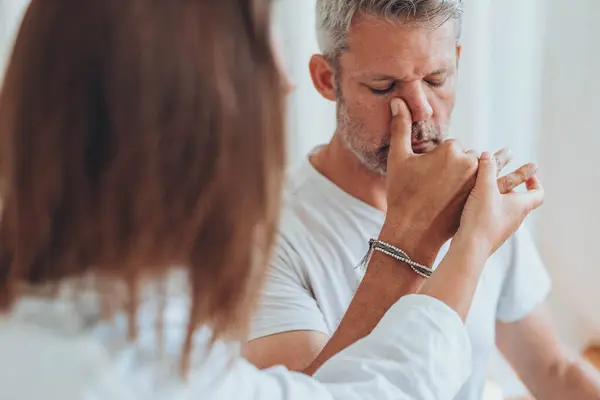 stock image A man sitting in lotus position and a woman practicing alternate nostril breathing exercises during a meditation session. High quality photo