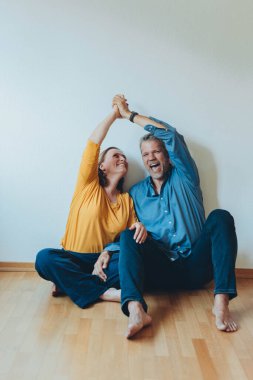 Mutlu bir çift yerde otururken evde eğleniyor. Yüksek kalite fotoğraf