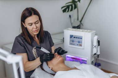 Profesyonel bir kadın kozmetik uzmanı kozmetoloji kliniğinde hidrosentez uygular. Yüksek kalite fotoğraf