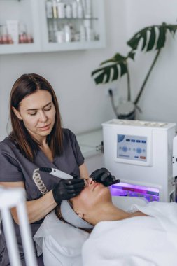 Profesyonel bir kadın kozmetik uzmanı kozmetoloji kliniğinde hidrosentez uygular. Yüksek kalite fotoğraf