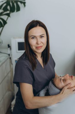 Güzel bir kadın güzellik salonunda cilt ve vücut bakımına düşkün bir yüz masajından hoşlanıyor. Yüksek kalite fotoğraf