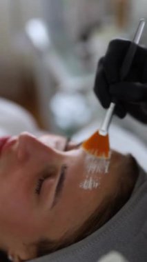 Kozmetik uzmanının kapanışı salondaki kadın müşteriler için yüz maskesi yapıyor. Dermatoloji, güzellik konsepti..