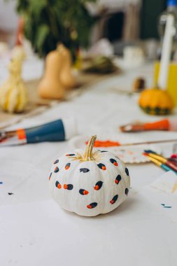 Çocuklar ve yetişkinler Cadılar Bayramı için balkabağı boyuyor, eğlenceli ve yaratıcı aktivitelerin tadını çıkarıyorlar. Yüksek kalite fotoğraf