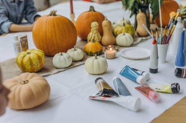 Çocuklar ve yetişkinler Cadılar Bayramı için balkabağı boyuyor, eğlenceli ve yaratıcı aktivitelerin tadını çıkarıyorlar. Yüksek kalite fotoğraf