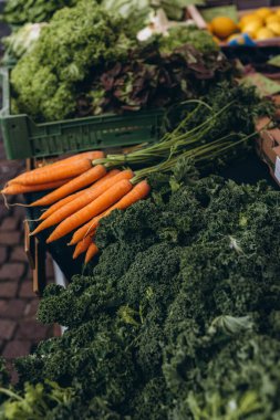 Diğer renkli sebzelerle çevrili bir pazarda sergilenen taze havuç ve brokoli. Yüksek kalite fotoğraf