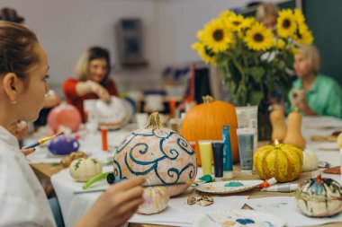 Children and adults painting pumpkins for Halloween, enjoying a fun and creative activity together. High quality photo clipart