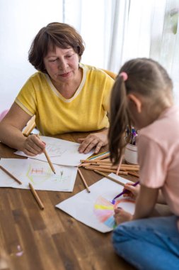Büyükannem ve torunum renkli kalemlerle birlikte vakit geçirmekten mutluluk duyarlar. Yüksek kalite fotoğraf