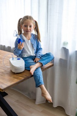 5 yaşındaki bir kız nefes alıyor, solunum sorunu için düzenli tedavi gören bir nebulizatör. Yüksek kalite fotoğraf