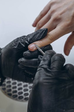 Manikür ustası, genç bir bayan müşterinin tırnaklarını şekillendirmek için güzellik salonunda çalışıyor. Yüksek kalite fotoğraf