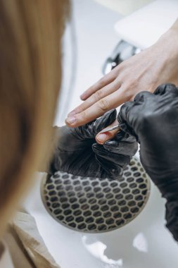 Manikür ustası, genç bir bayan müşterinin tırnaklarını şekillendirmek için güzellik salonunda çalışıyor. Yüksek kalite fotoğraf