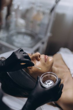 Orta yaşlı bir kadın kozmetik kliniğinde yüz soyma tedavisi görüyor. Yüksek kalite fotoğraf