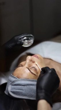 Orta yaşlı bir kadın kozmetik kliniğinde yaşlanma karşıtı yüz soyma tedavisi görüyor.