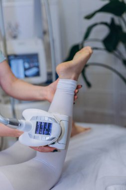 Profesyonel bir güzellik kliniğinde ameliyat sırasında cihazı tutan LPG masaj uzmanı. Yüksek kalite fotoğraf