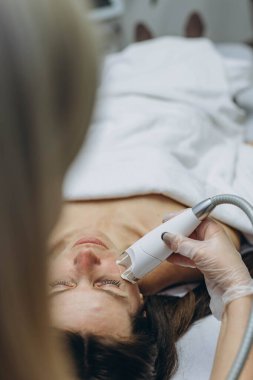 Profesyonel kozmetik uzmanı güzellik salonunda yenilenme için LPG yüz masajı yapıyor. Yüksek kalite fotoğraf