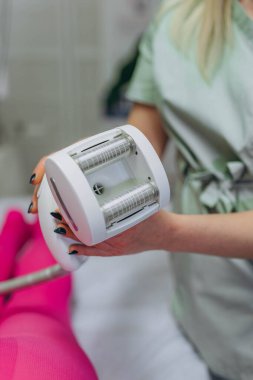LPG masaj prosedürü. Lipomasaj aleti tutan terapistin elleri. Yaklaş, seçici odaklanma. Yüksek kalite fotoğraf