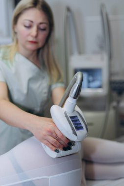 LPG masaj prosedürü. Lipomasaj aleti tutan terapistin elleri. Yaklaş, seçici odaklanma. Yüksek kalite fotoğraf