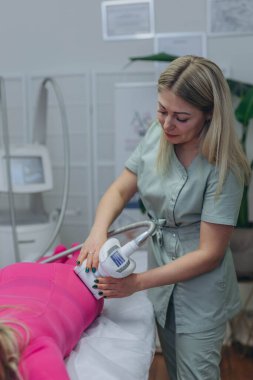 LPG masaj prosedürü. Lipomasaj aleti tutan terapistin elleri. Yaklaş, seçici odaklanma. Yüksek kalite fotoğraf