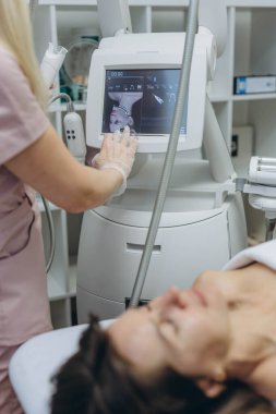 Profesyonel kozmetik uzmanı güzellik salonunda yenilenme için LPG yüz masajı yapıyor. Yüksek kalite fotoğraf