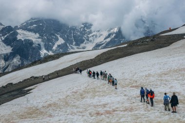 Aips,Italia-July 28,2024, Group child tourists hiking through snowy mountains in the Alps. High quality photo clipart